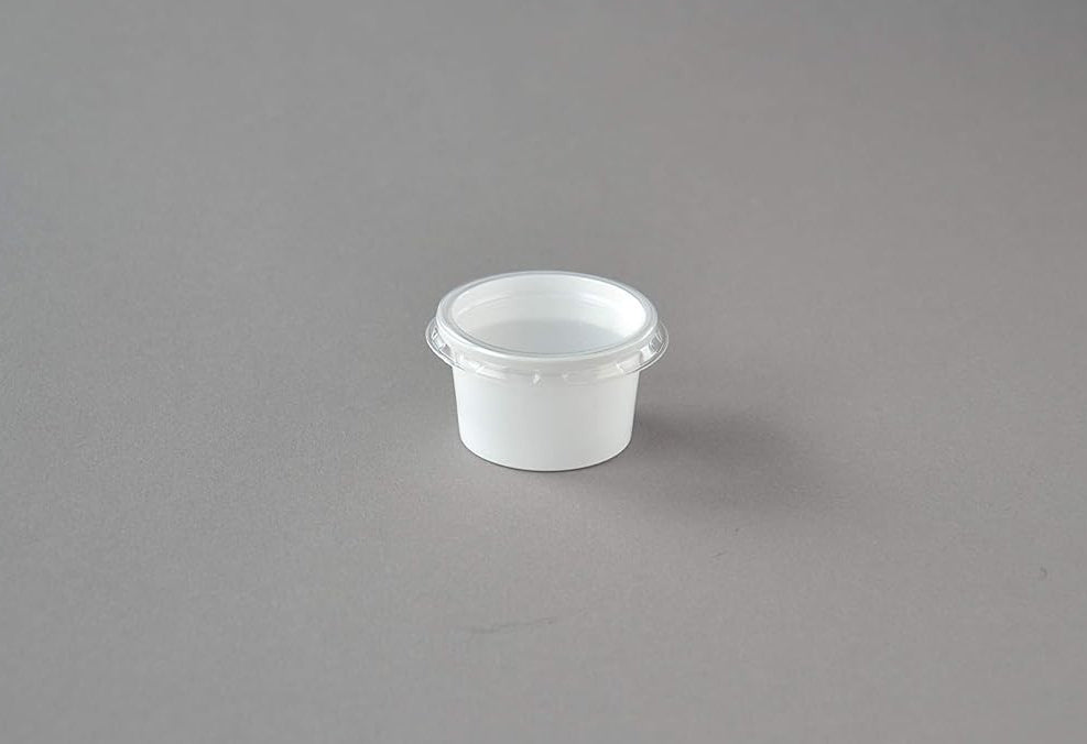 Weiße 30 ml Dressingbecher mit transparentem Deckel, auf grauem Hintergrund platziert, ideal für Saucen und Dressings.