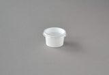 Weiße 30 ml Dressingbecher mit transparentem Deckel, auf grauem Hintergrund platziert, ideal für Saucen und Dressings.