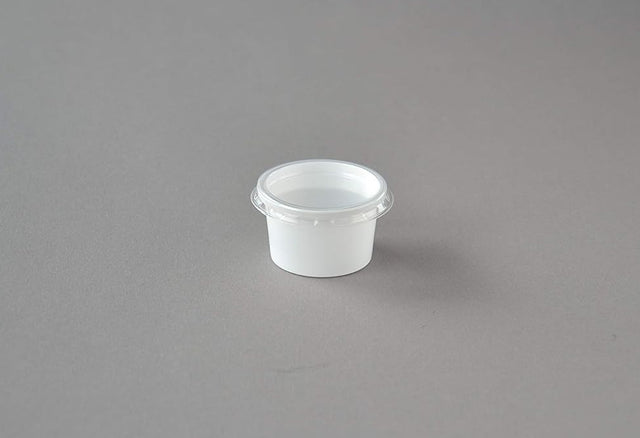 Weiße 30 ml Dressingbecher mit transparentem Deckel, auf grauem Hintergrund platziert, ideal für Saucen und Dressings.